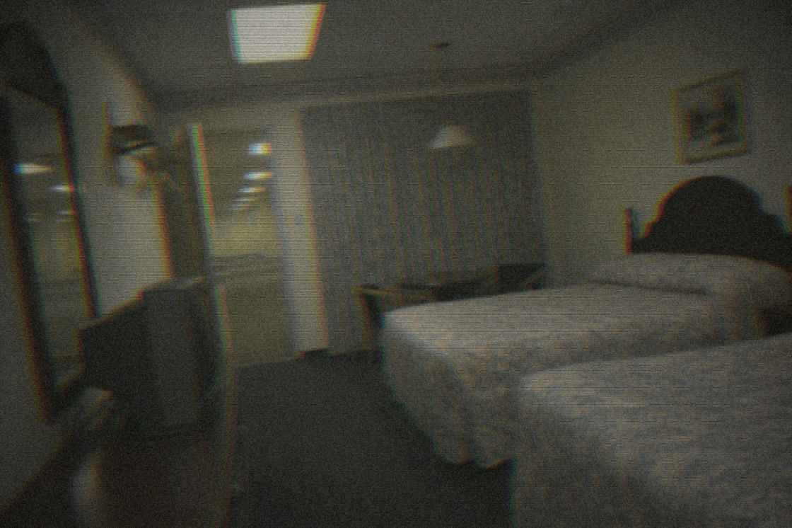 The same motel room emptied and rebuilt as a dim, carpeted liminal space, graded onto worn VHS tape.