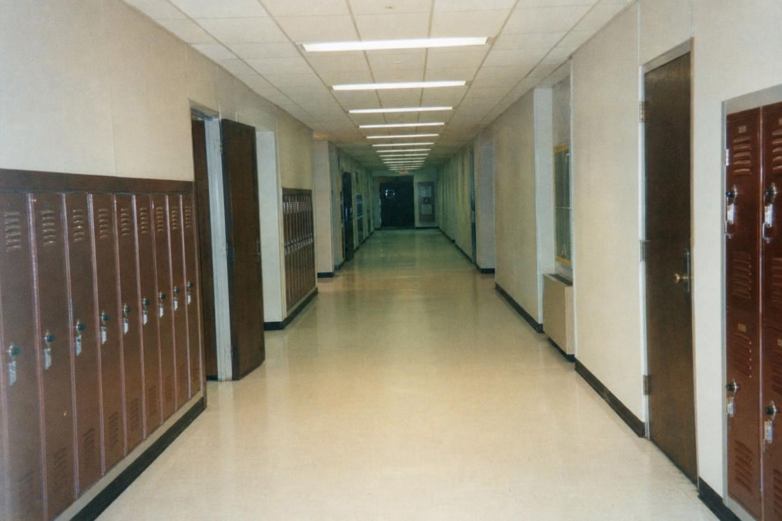 Before: a narrow apartment-building hallway with numbered doors and carpet.